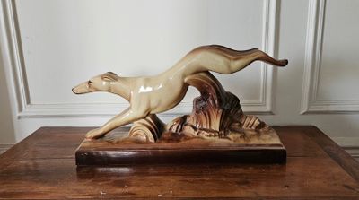 une figurine représentant un chien en train de courir, posée sur une table en bois