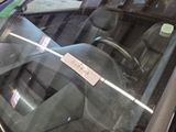a sticker on the windshield of a car that is parked in a parking lot