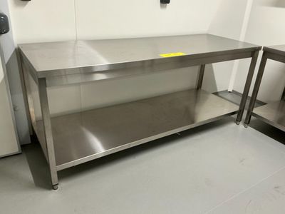 une table en acier inoxydable sur laquelle est posée une étiquette jaune
