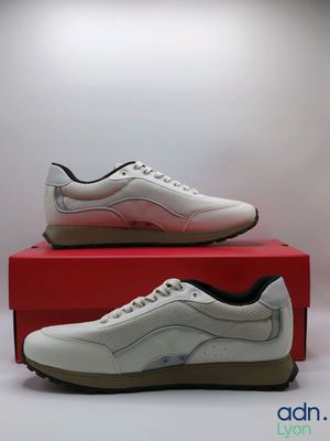 a pair of white sneakers sitting on top of a red box