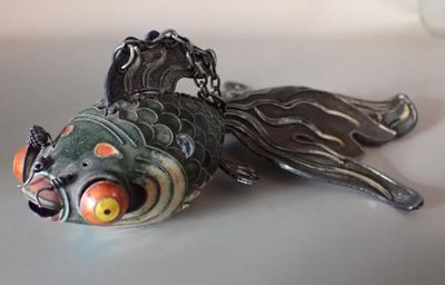 un objet en forme de poisson posé sur une table et entouré d'une chaîne