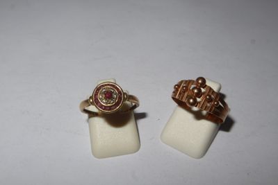 two gold rings with a pink stone on top of them