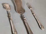 three forks and a knife on a table
