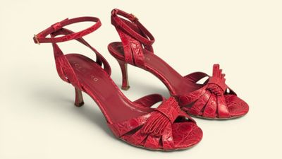the woman is wearing red shoes with bows on them