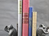 trois livres posés l'un à côté de l'autre sur une table
