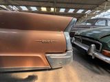 several old cars are parked in a garage with a roof