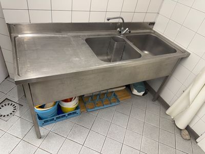 un évier en acier inoxydable dans le coin d'une salle de bains