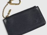 a close up of a black purse with a gold keychain