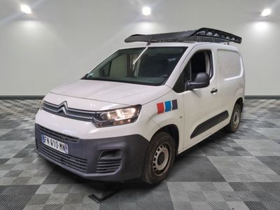 la camionnette blanche est garée dans une pièce au sol en damier