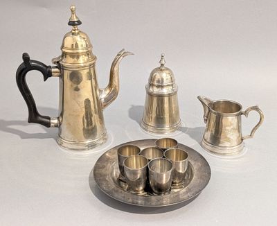 un plateau en argent sur lequel sont posés une théière et des tasses en argent