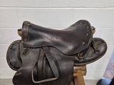 une selle et un chapeau posés sur un support dans une pièce