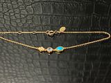 un bracelet en or orné d'une pierre turquoise