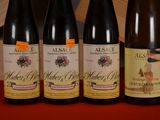 four bottles of wine are lined up on a red table