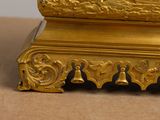 a gold clock sitting on top of a table