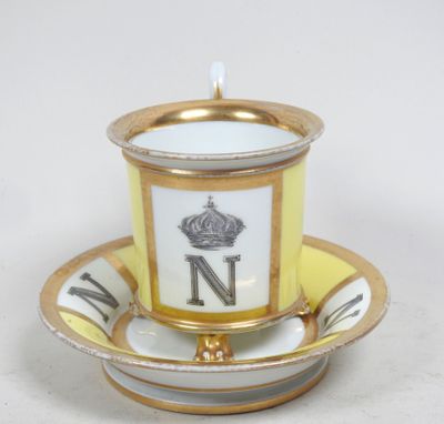 une tasse et une soucoupe ornées d'un liseré doré et d'une couronne
