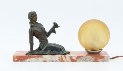 statue of a woman sitting on a marble base with a yellow ball