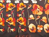 a black scarf with orange and white flowers on it