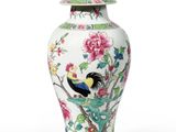 a white vase with a bird and flowers on it