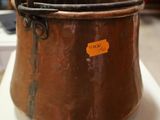 a large copper pot with a tag on it