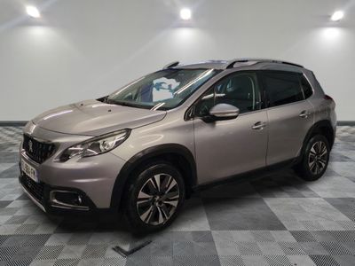 une voiture argentée est garée dans une pièce au sol en damier