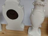 three white vases sitting on a table next to each other