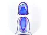 figurine en verre violet et bleu posée sur une surface blanche