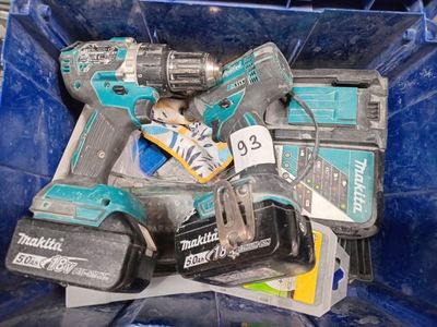 beaucoup d'outils dans un bac bleu posé par terre