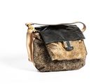 le sac à main marron et noir est posé sur une surface blanche