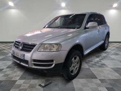 une photo d'un SUV Volkswagen argenté garé dans un garage