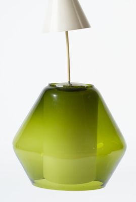 a green glass lamp with a white shade on it