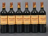 six bottles of wine are lined up in a row on a table
