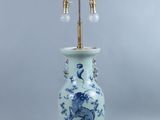 une lampe de table bleue et blanche avec un pied en laiton et un vase bleu et blanc orné d'un dragon