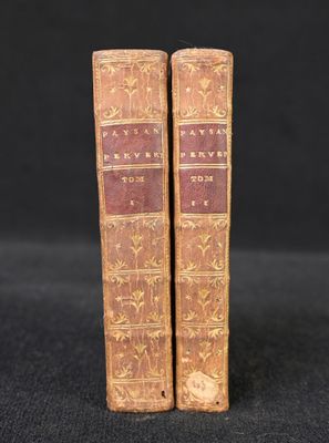 a pair of old books sitting on top of a black surface