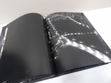 an open book with black pages on a white table