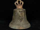 a bell with a crown on top of it on a black background