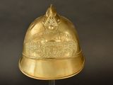 gold plated helmet on stand on black background with black background