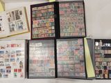 a lot of stamps on a table with a binder