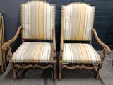 two chairs with striped upholstered cushions and a wooden frame