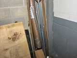 a pile of baseball bats sitting in the corner of a room