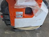 an orange and white lawn mower sitting on top of a cement floor