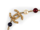 a close up of a necklace with pearls and a bird on it
