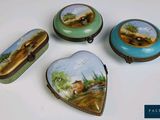 trois petites boîtes en forme de cœur, ornées de peintures, posées sur une table