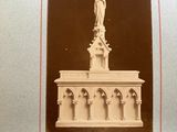 an old photo of a statue of a woman on top of a building