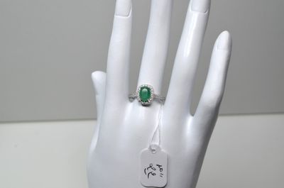 une main sur laquelle est passée une bague, à laquelle est accrochée une étiquette
