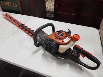 an orange and black hedger sitting on top of a white table