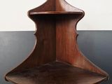 a wooden corner shelf with a shelf on it