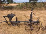 une charrue à l'ancienne posée au milieu d'un champ