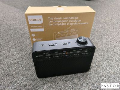 une radio noire posée par terre à côté d'une boîte