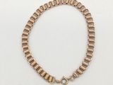 un bracelet en or avec un fermoir sur fond blanc