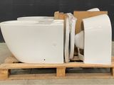 a white toilet sitting on top of a pallet